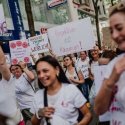 Frauen protestieren mit Schildern gegen die Kürzungen
